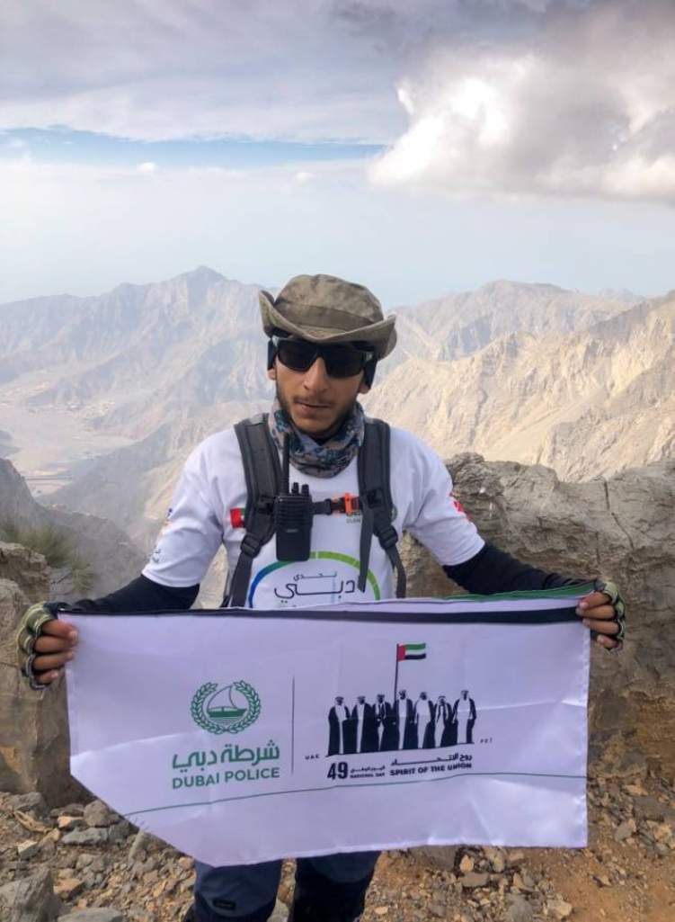 شرطي يتسلق جبل جيس احتفالاً باليوم الوطني الإماراتي
