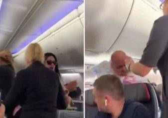 بالفيديو.. امرأة تحطم ”لابتوب“ على رأس حبيبها في رحلة طيران