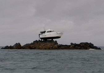 قارب معلق على صخرة في عرض البحر.. ما قصته؟
